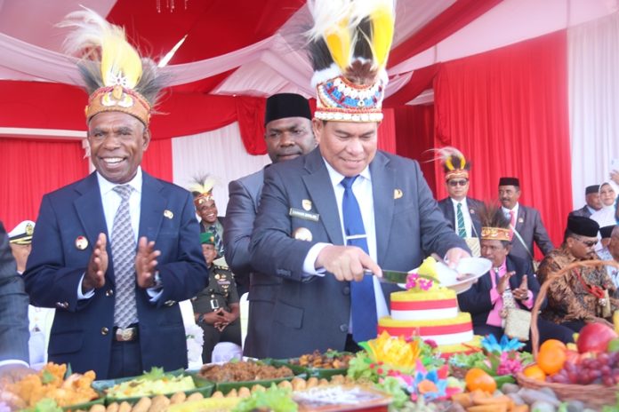 Bupati Fakfak. Samaun Dahlan lakukan proses pemotongan kue tumpeng HUT Ke-125 Kabupaten Fakfak. 16 November 2025 kemarin didampingi Wakil Bupati Fakfak. Donatus Nimbitkendik di Lokasi RTH. foto ; rustam rettob/mataradarindonesia.com