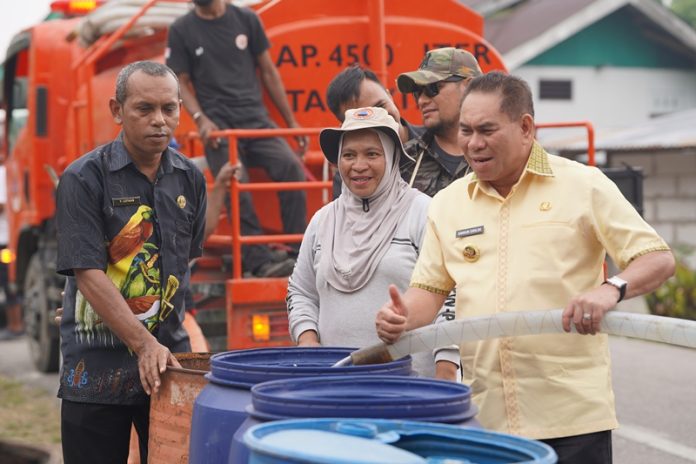 Samaun Dahlan. Bupati Fakfak ketika memegang nosel selang air bersih untuk melayani warga di Distrik Fakfak Timur Tengah, Kamis, 8 Oktober 2026, didampingi Kepala BPBD Fakfak. Kerty Uswanas, foto ; rustam rettob/mataradarindonesia.com