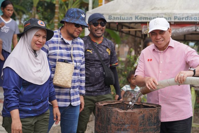 Bupati Fakfak. Samaun Dahlan (Kemeja warna pink), Kepala Dinas Kominfo. M Taufiq Safat (Kemeja kotak gari biru), Plt Kepala BPBD. Kerty Uswanas, salah satu staf khusus Bupati. Rusdy Faruk saat mengisi air bersih untuk warga di Kampung Werpigan. foto ; rustam rettob/mataradarindonesia.com